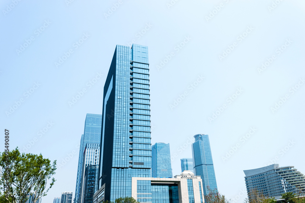 Modern glass buildings and green tree branches