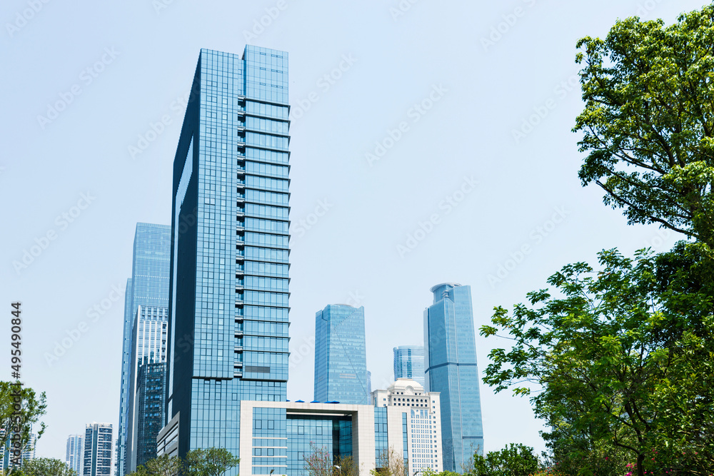 Modern glass buildings and green tree branches