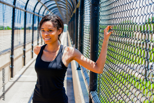 African American woman in fitness clothing stretching outdoors