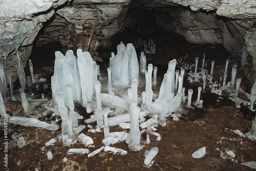 The cave in winter grow icicles, ice blocks on the floor, a karst cave, the study of underground tunnels, speleology.