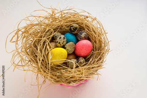 Decorative,colorful,Easter Eggs in nesting-box with quail eggs.Easter celebration concept