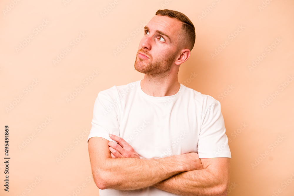 Young caucasian man isolated on beige background dreaming of achieving goals and purposes Young caucasian man isolated on beige background dreaming of achieving goals and purposes