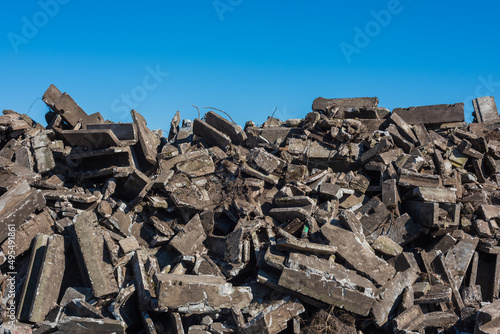 big pile of construction rubble of a demolished building under a blue sky