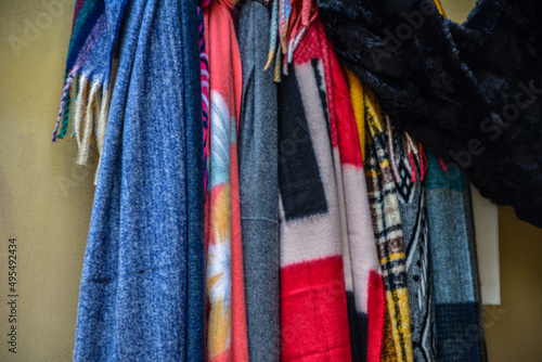 Different beautiful scarves hanging on rack