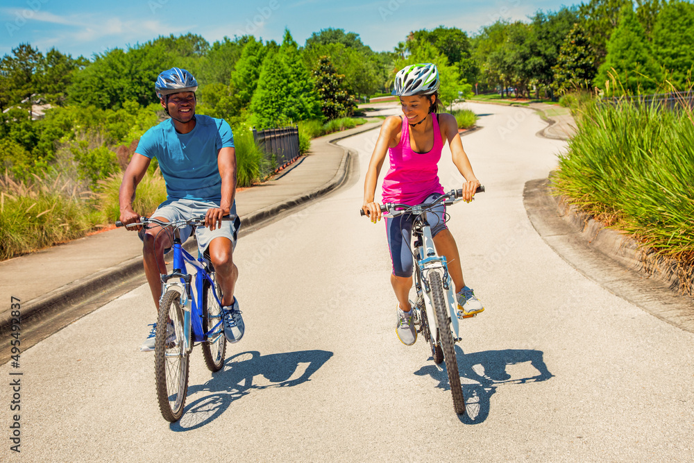 Fototapeta premium Afro American male and female cycling on road