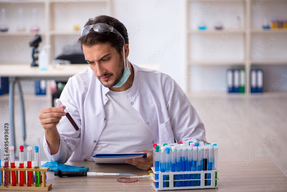 Young male chemist working at the lab Young male chemist working at the lab