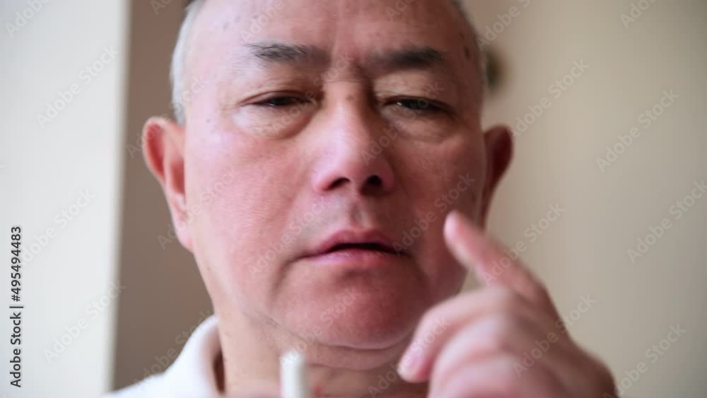 A matured man suffering from hay fever applying a nasal spray to relief the symptoms of block nose and sneezing. A matured man suffering from hay fever applying a nasal spray to relief the symptoms of block nose and sneezing.