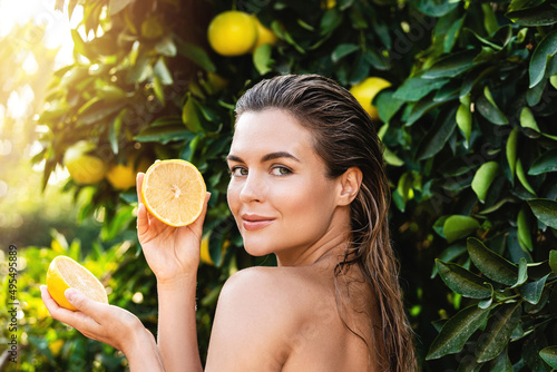 Beautiful woman with smooth skin with a lemon fruit in her hands photo