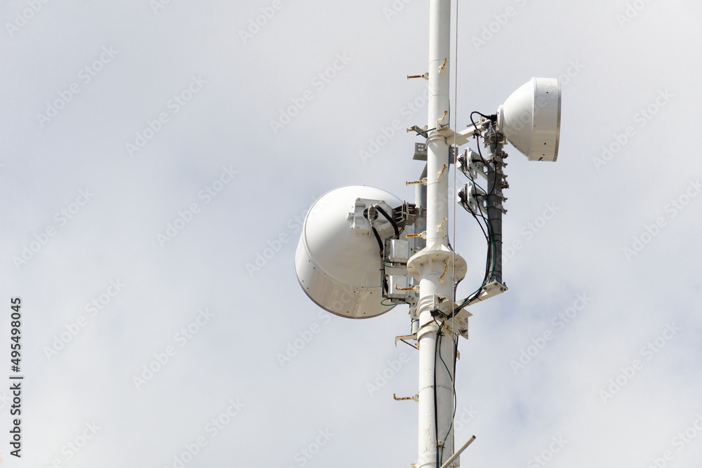 High speaker with two white speakers, Warning system. Loudspeakers on a pole against a cloudy sky.