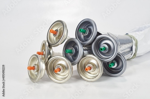 A large number of caps from cans of aerosol paint for graffiti. Smeared with colored paint nozzles lie in a huge pile