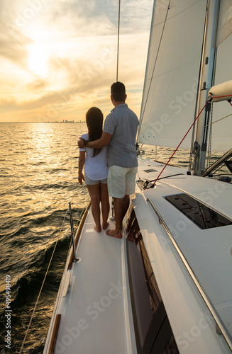 Young Latino couple watching sunset from luxury yacht