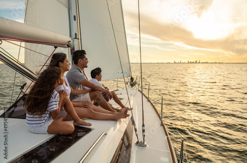 Hispanic family sailing on private yacht at sunset © Spotmatik