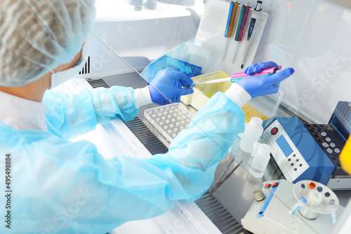 medical officer of the PCR laboratory conducts a study holding a dispenser in his hands. photo