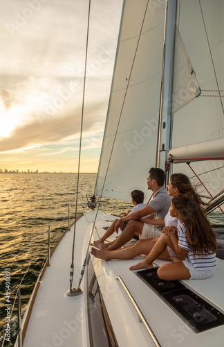 Young Latino family sitting on yacht at sunset