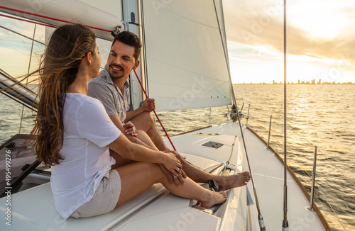 Attractive Hispanic couple relaxing on yacht at sunrise