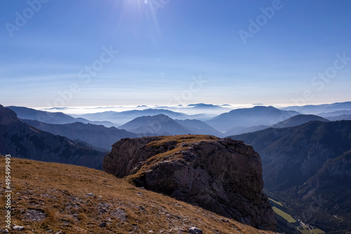 Fototapeta Naklejka Na Ścianę i Meble -  A panoramic view on the mountain peaks of the Hochschwab Region in Upper Styria, Austria. Cloudless weather on a sunny summer day in the Alps. Blue misty valley and soft hills. Concept freedom