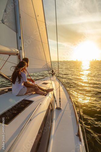 Latin American couple sailing towards horizon at sunset