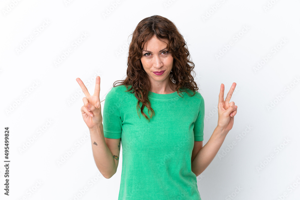 Young woman with curly hair isolated on white background showing victory sign with both hands Young woman with curly hair isolated on white background showing victory sign with both hands