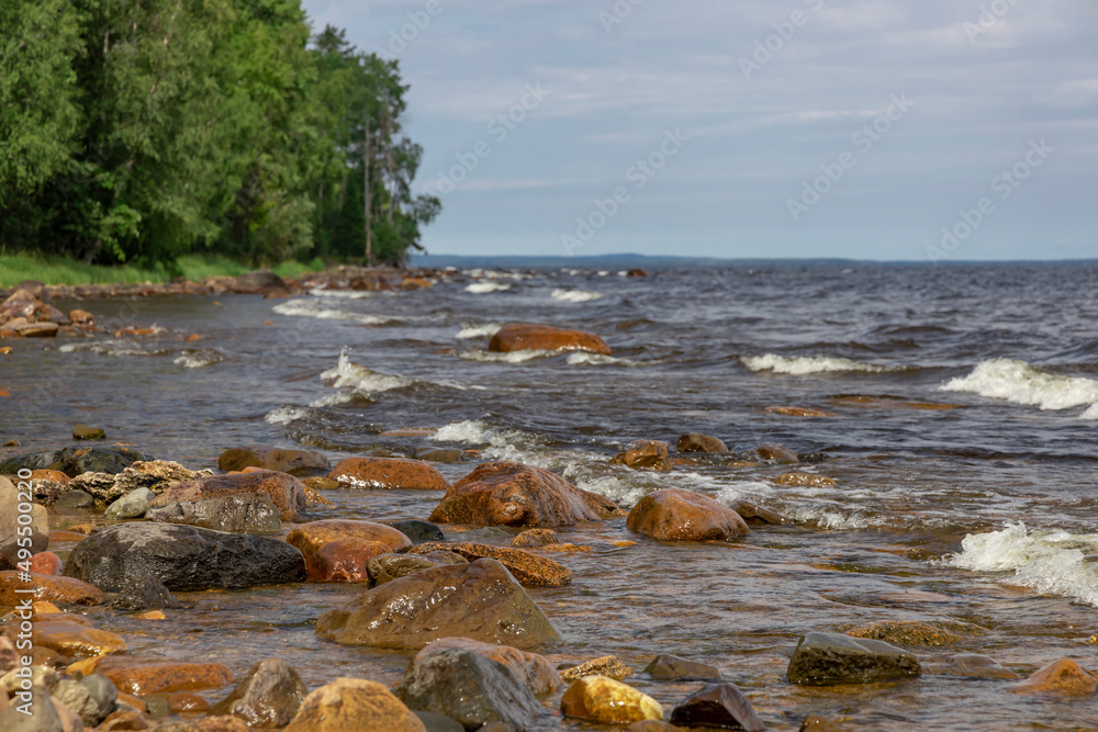Landscape of Lake Onega on a sunny summer day. Beautiful rocky shore and water.
