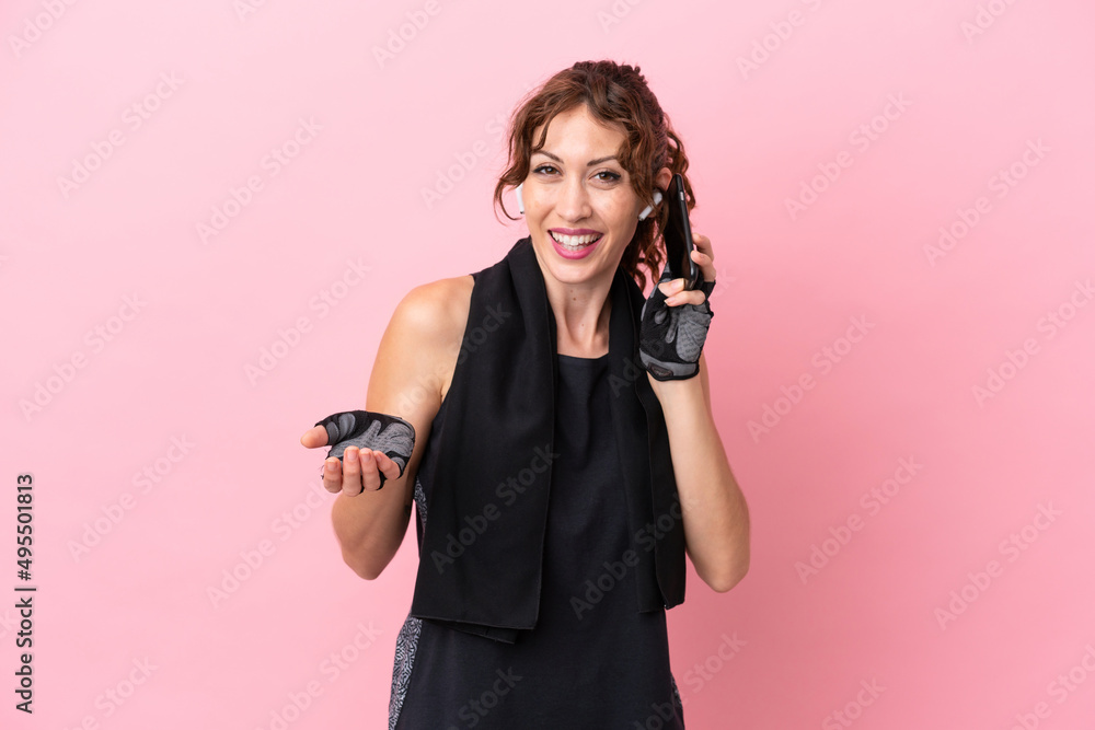 Sport sport woman with towel isolated on pink background keeping a conversation with the mobile phone with someone Sport sport woman with towel isolated on pink background keeping a conversation with the mobile phone with someone