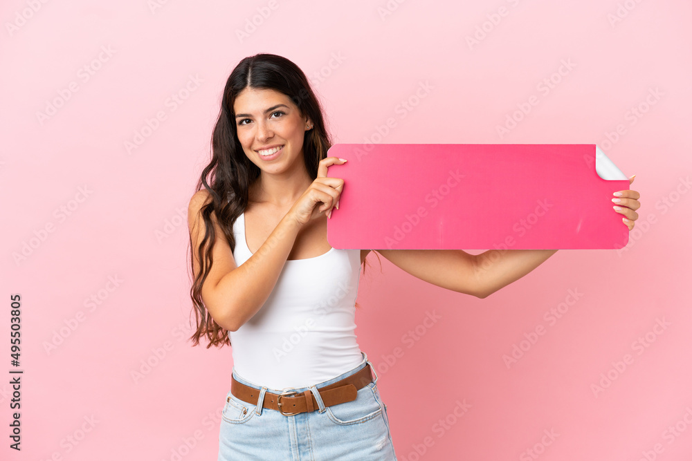 Young caucasian woman isolated on pink background holding an empty placard Young caucasian woman isolated on pink background holding an empty placard