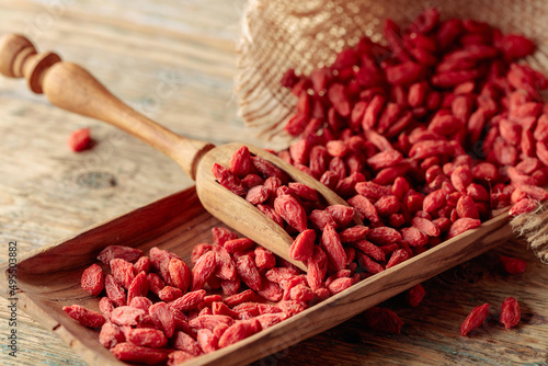 Dried goji berries on a wooden table.