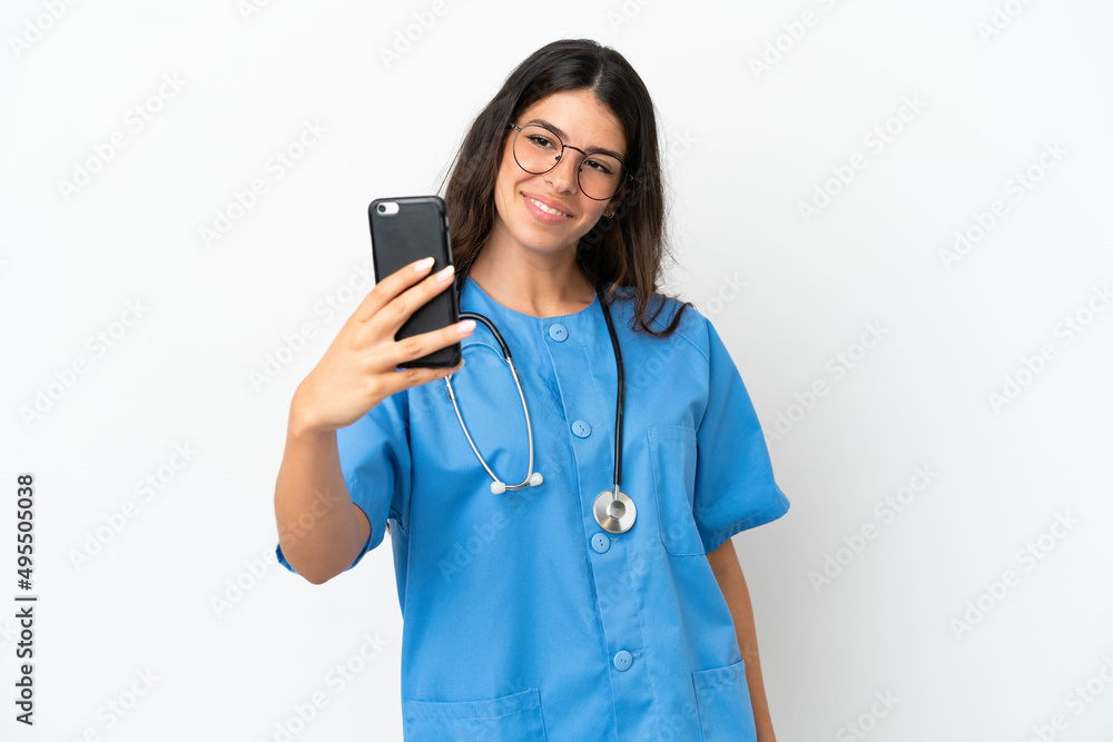 Young surgeon doctor caucasian woman isolated on white background making a selfie Young surgeon doctor caucasian woman isolated on white background making a selfie