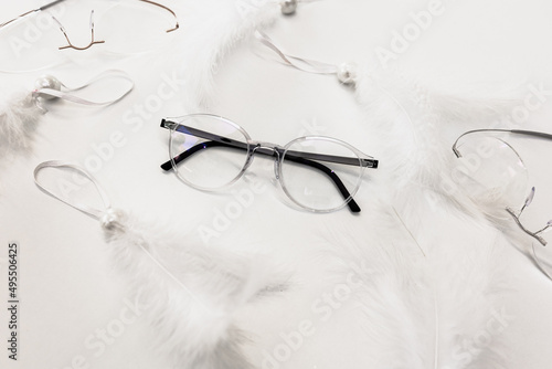 Glasses on a white table surrounded by feathers