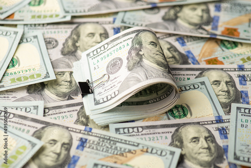 Photo of pile of one hundred dollar bills with black binder clip and dollar banknotes Photo of pile of one hundred dollar bills with black binder clip and dollar banknotes