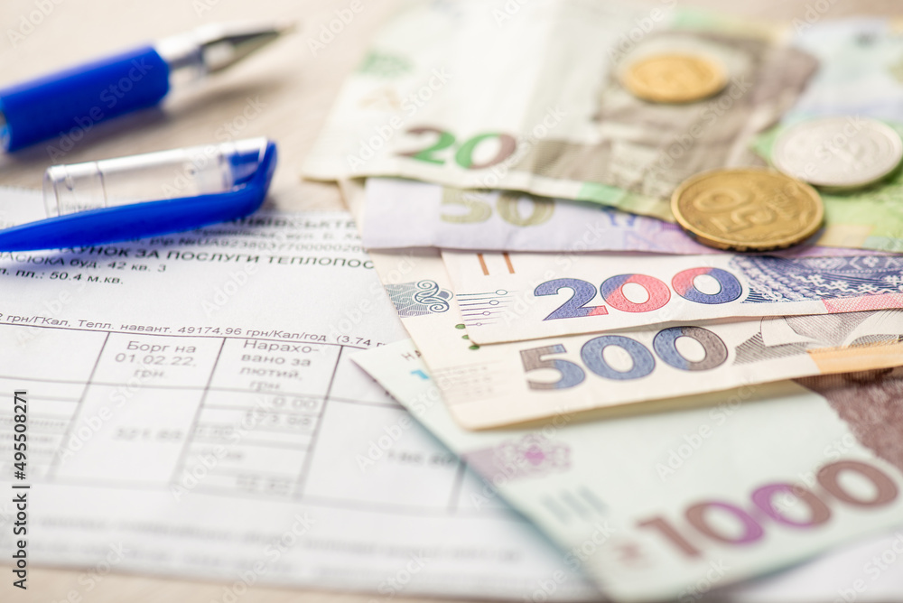 Close up photo of pen utility payments ukrainian hryvnia banknotes and coins Close up photo of pen utility payments ukrainian hryvnia banknotes and coins