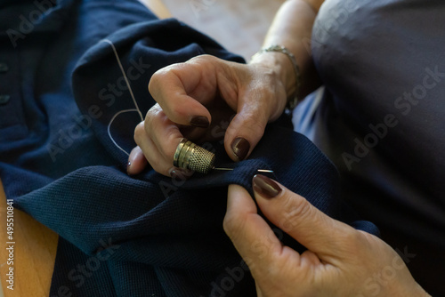 Canvas-taulu Unrecognizable woman sewing by hand with thread and thimble