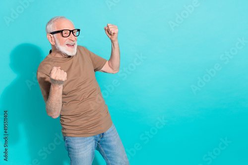 Portrait of attractive cheerful lucky grey-haired man having fun rejoicing isolated over bright blue color background