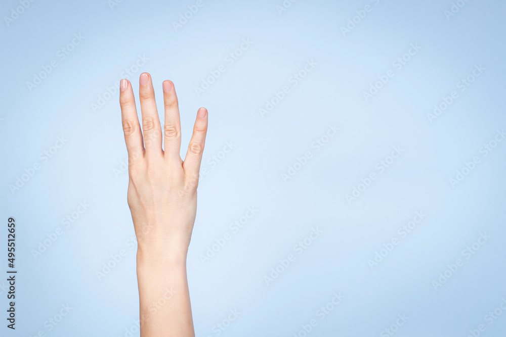 Female hand shows number four. Woman hand showing four fingers, pointing fingers up on light blue background Female hand shows number four. Woman hand showing four fingers, pointing fingers up on light blue background