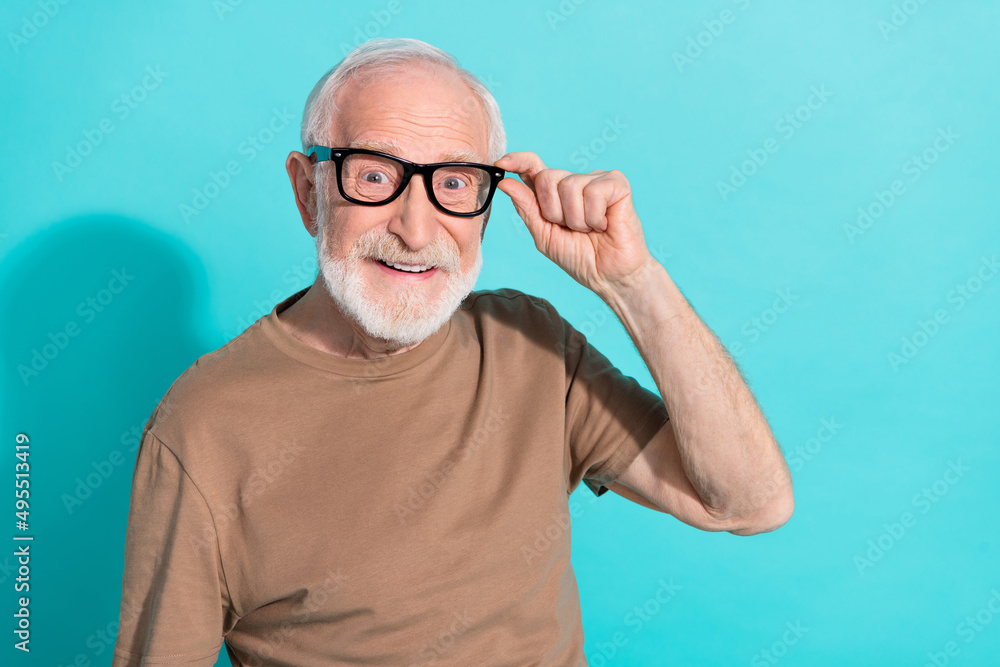 Portrait of attractive cheerful intellectual grey-haired man touching specs isolated over bright blue color background Portrait of attractive cheerful intellectual grey-haired man touching specs isolated over bright blue color background