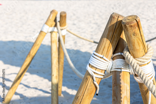 Close-up, wooden posts on the sandy beach.