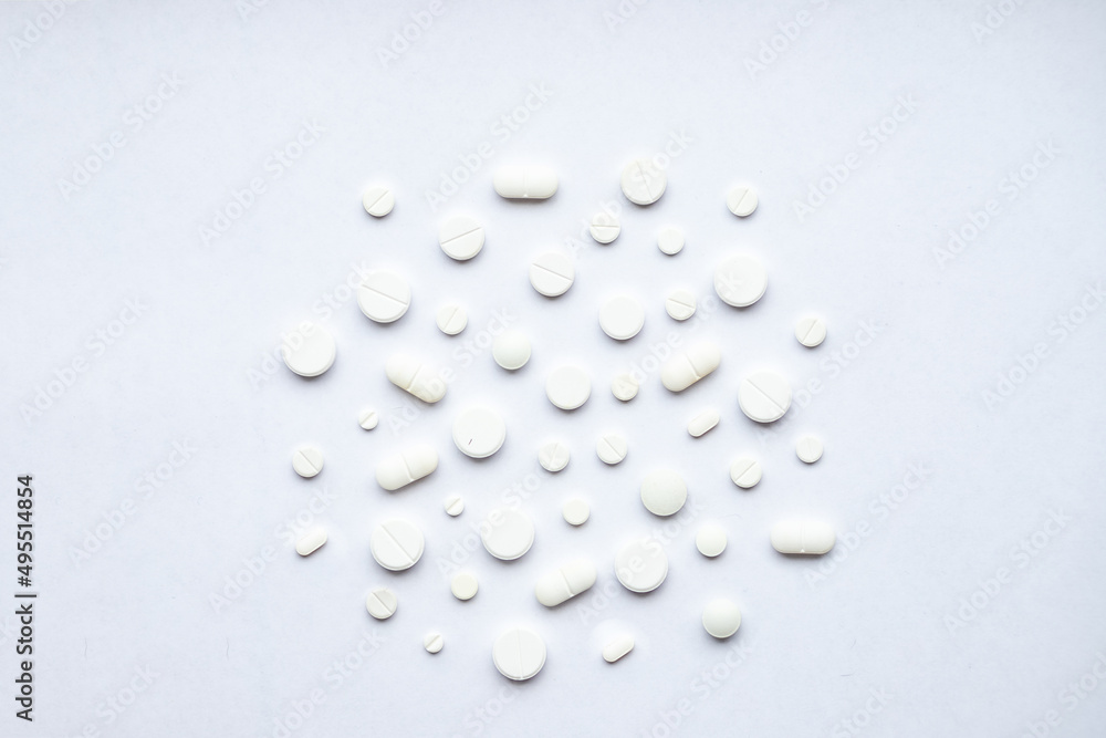 Flat lay composition with bunch of different pills scattered on table . Pile of opened medication on white background. .Medications and Phramacy. Flat lay composition with bunch of different pills scattered on table . Pile of opened medication on white background. .Medications and Phramacy.