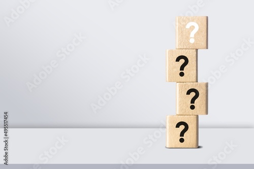 Wooden cube block with question mark mean what on table background