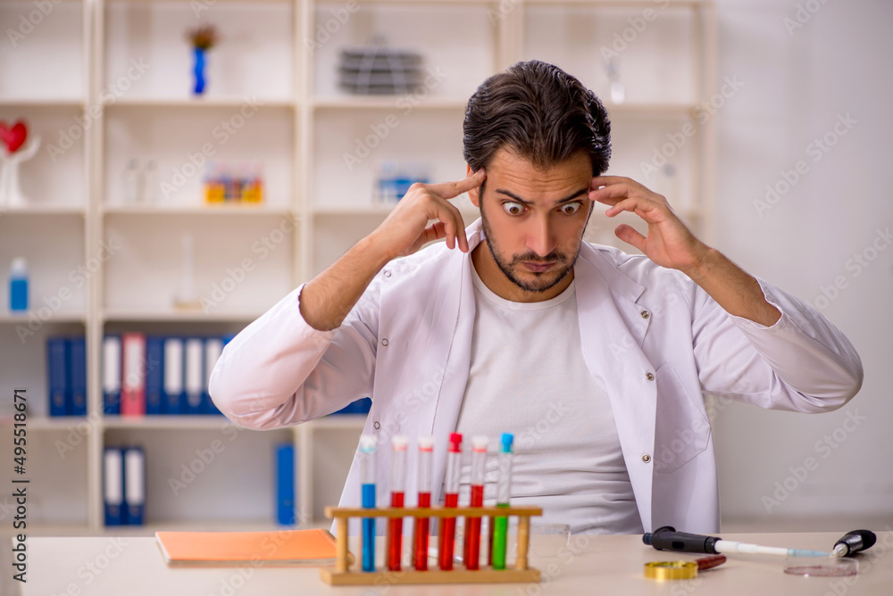 Young male chemist working at the lab Young male chemist working at the lab