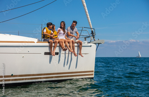 Happy young Latino family sitting on luxury yacht