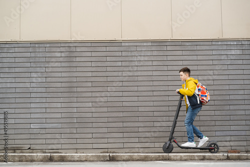 Handsome teenager riding an electric scooter
