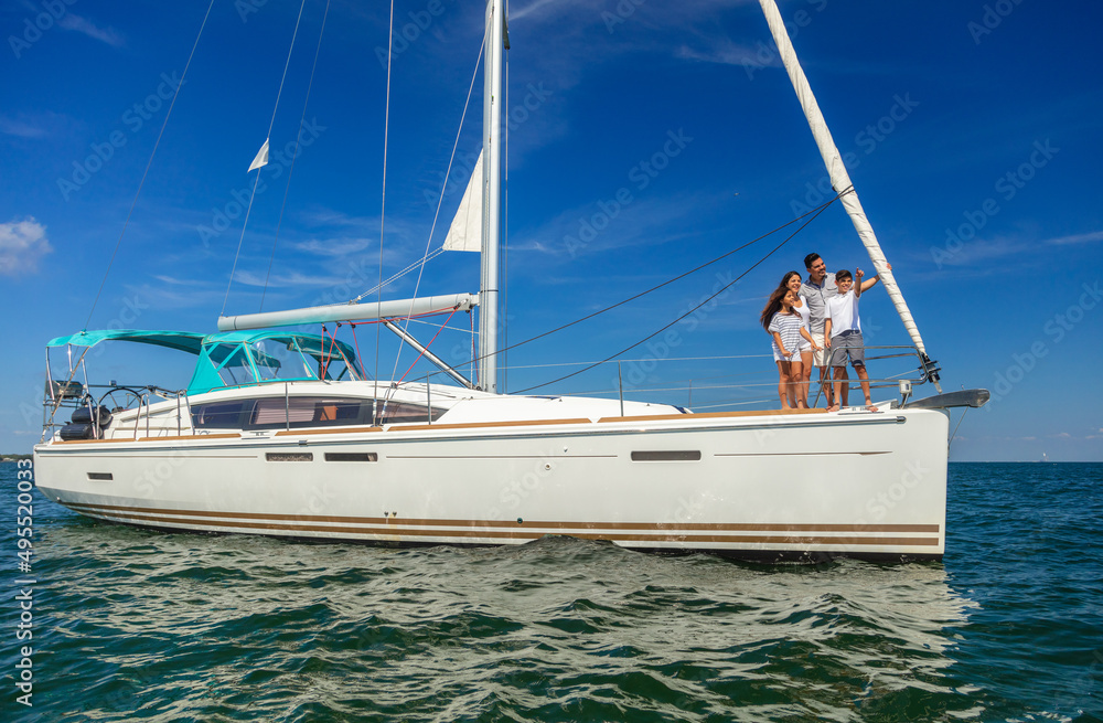 © Spotmatik - Latino family standing on yacht in tropical ocean © Spotmatik - Latino family standing on yacht in tropical ocean