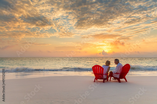 Mature couple enjoying ocean sunset on beach Bahamas