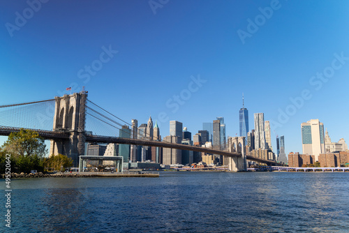 Lower Manhattan skyscraper stands behind Brooklyn Bridge beyond the East River on November 5  2021 in New York City NY USA. NYC Ferry runs on East River.