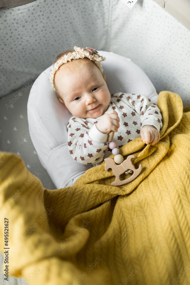 a small beautiful baby lies in his cradle in a soft cocoon