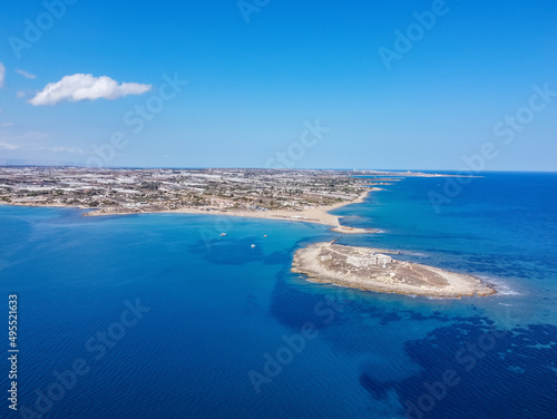 Aerial drone view of island and beach of Isola delle Correnti. Lighthouse surrounded by clear turquoise sea water in Portopalo di capo Passero  Sicily