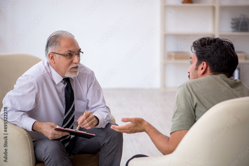 Obraz premium Young man visiting old psychologist