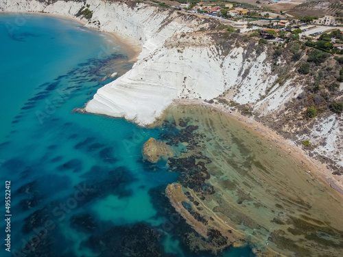 Aerial view of white rocky cliffs at Scala dei Turchi, Sicily, Italy, with turquoise clear water. Drone shot of the limestone rock formation and beach