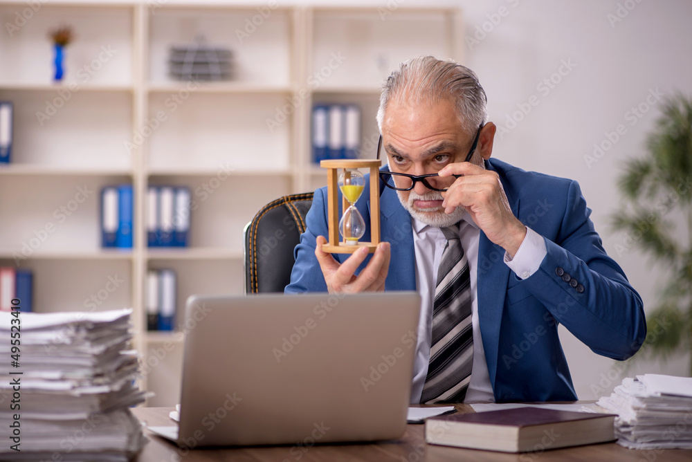 Old male employee in time management concept Old male employee in time management concept