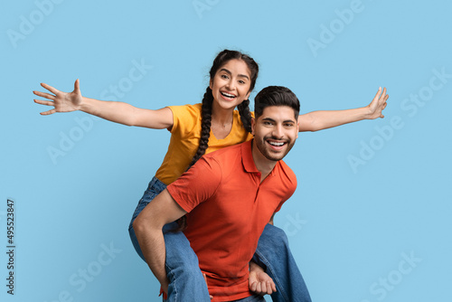 Cheerful Arab Couple Having Fun Together Over Blue Studio Background