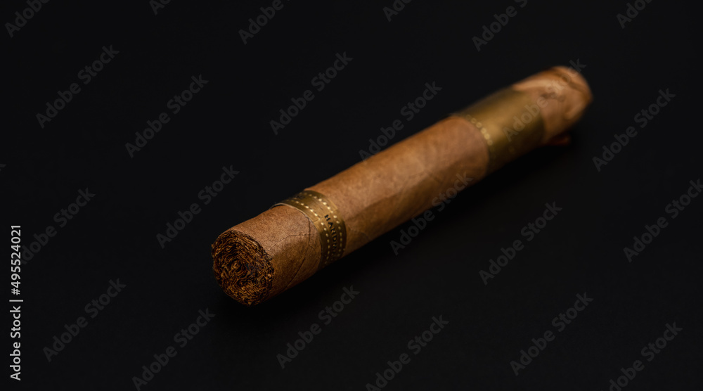 Single cigar. Handcrafted Brown cigar made with real tobacco leaves on dark background